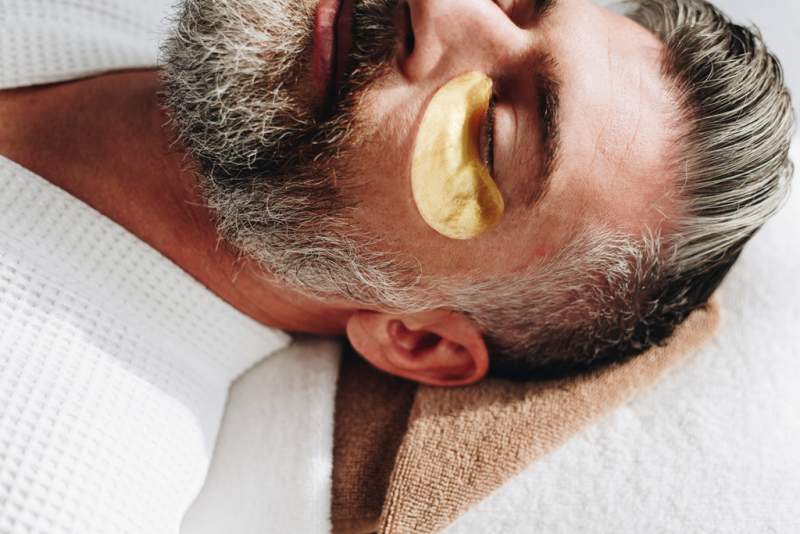 man-relaxing-with-a-golden-eye-mask-treatment